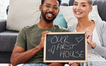 A man and a woman holding a sign.