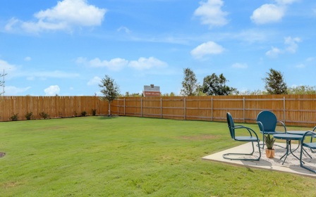 A backyard with chairs and a table.