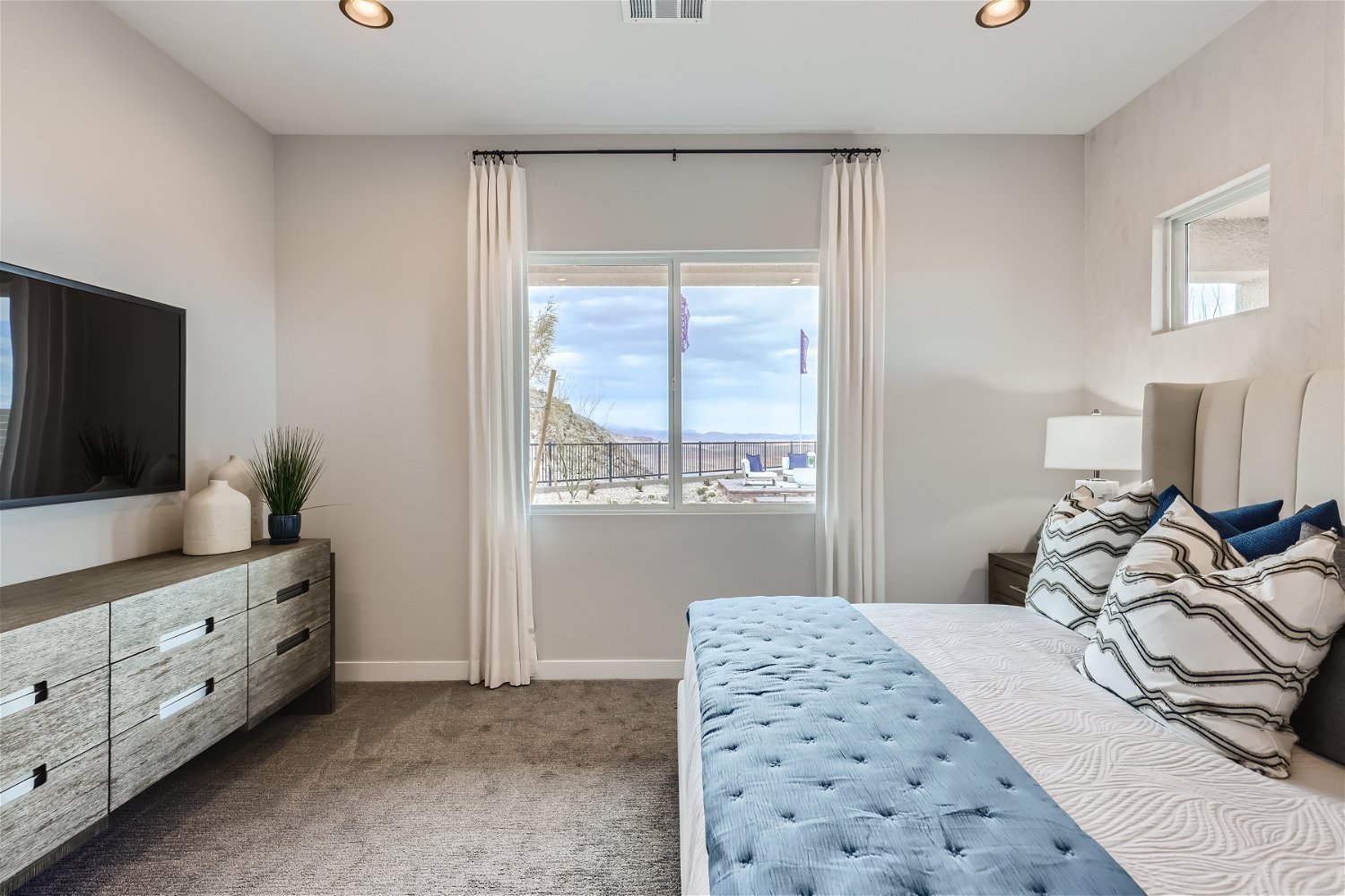 A bedroom with a large window.