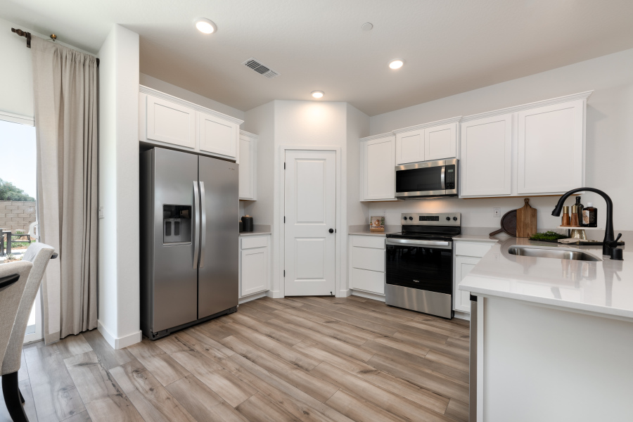 A kitchen with white cabinets.
