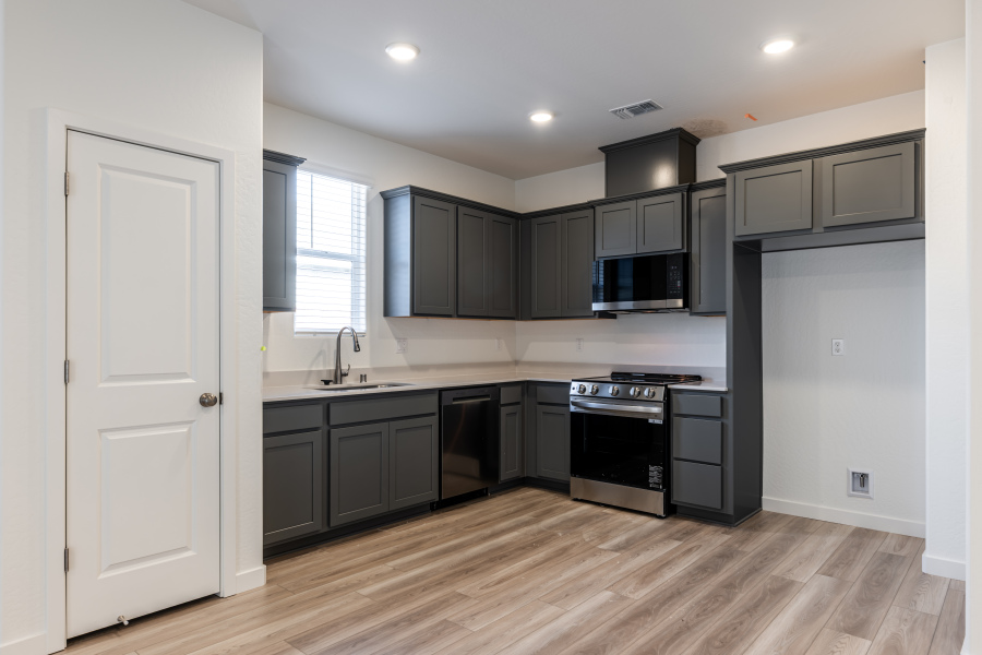 A kitchen with black cabinets.