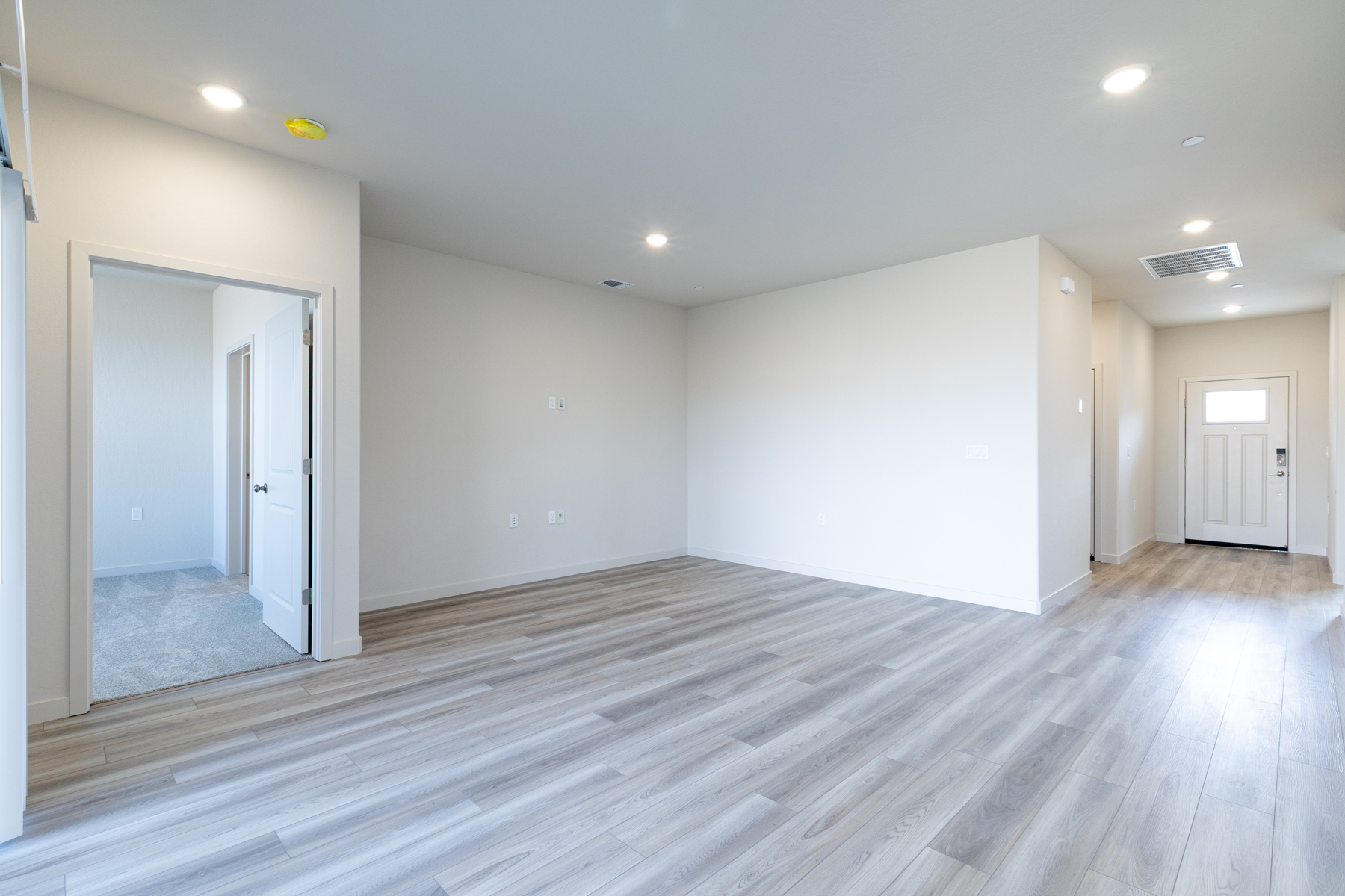 A room with white walls and wood floors.