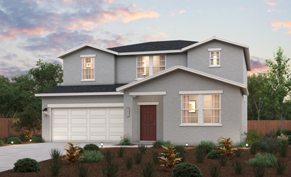 A house with a garage and bushes in front of it.