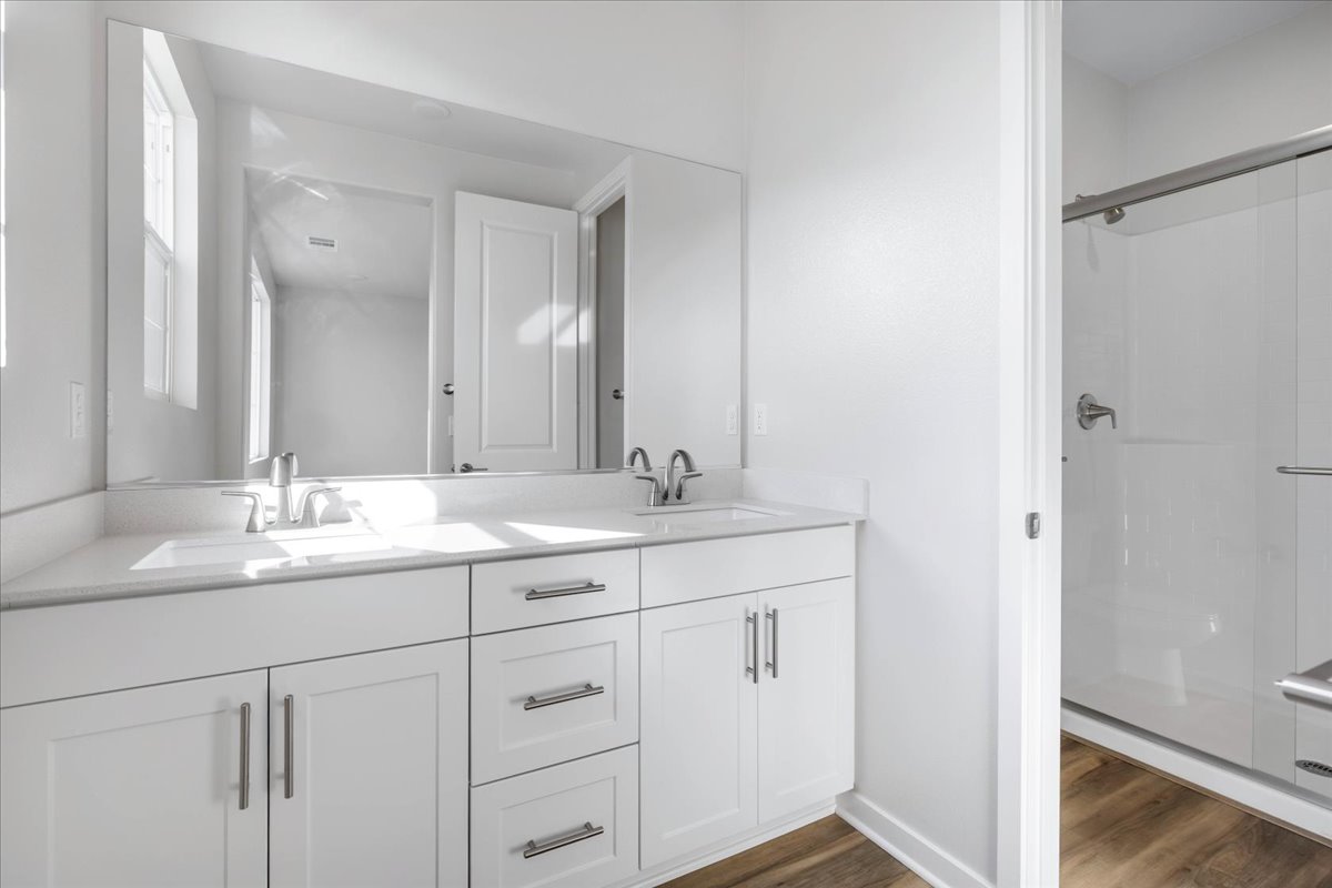 A bathroom with white cabinets.