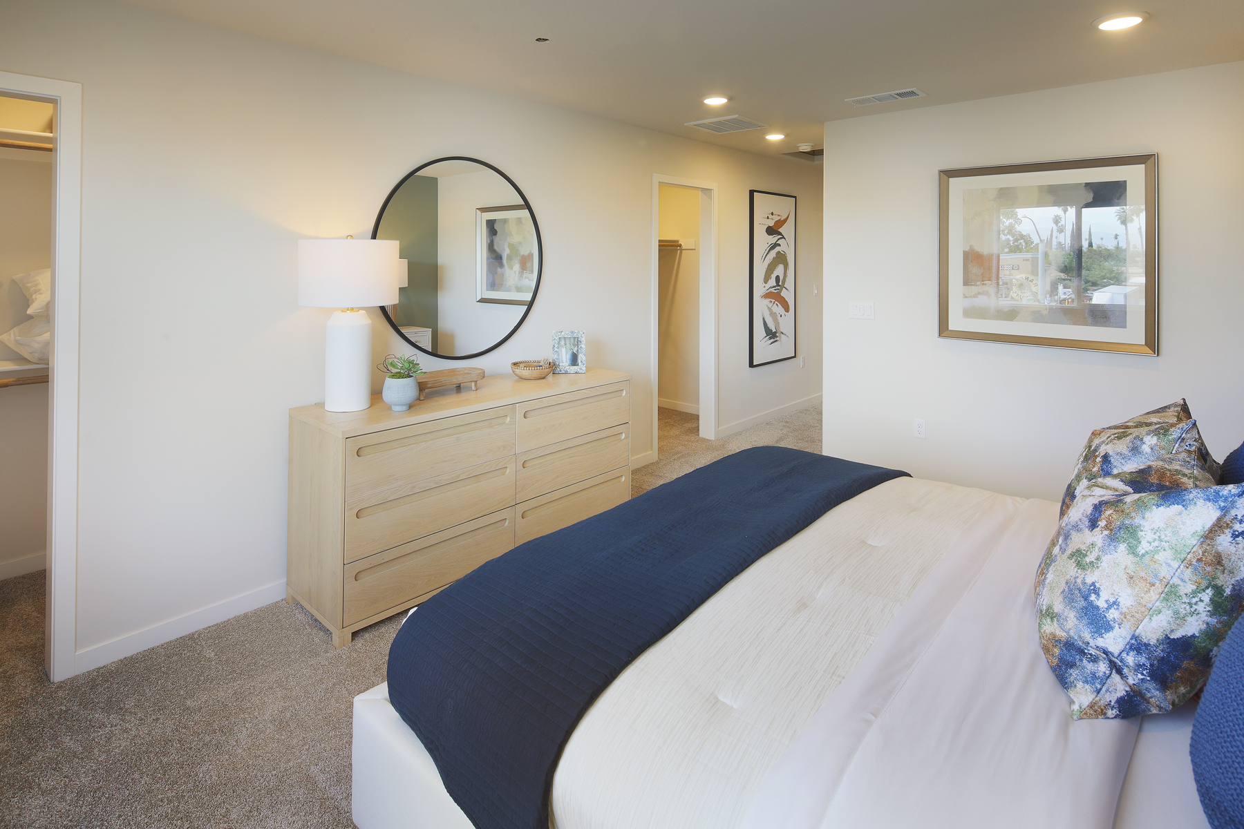 A bedroom with a bed and a mirror.