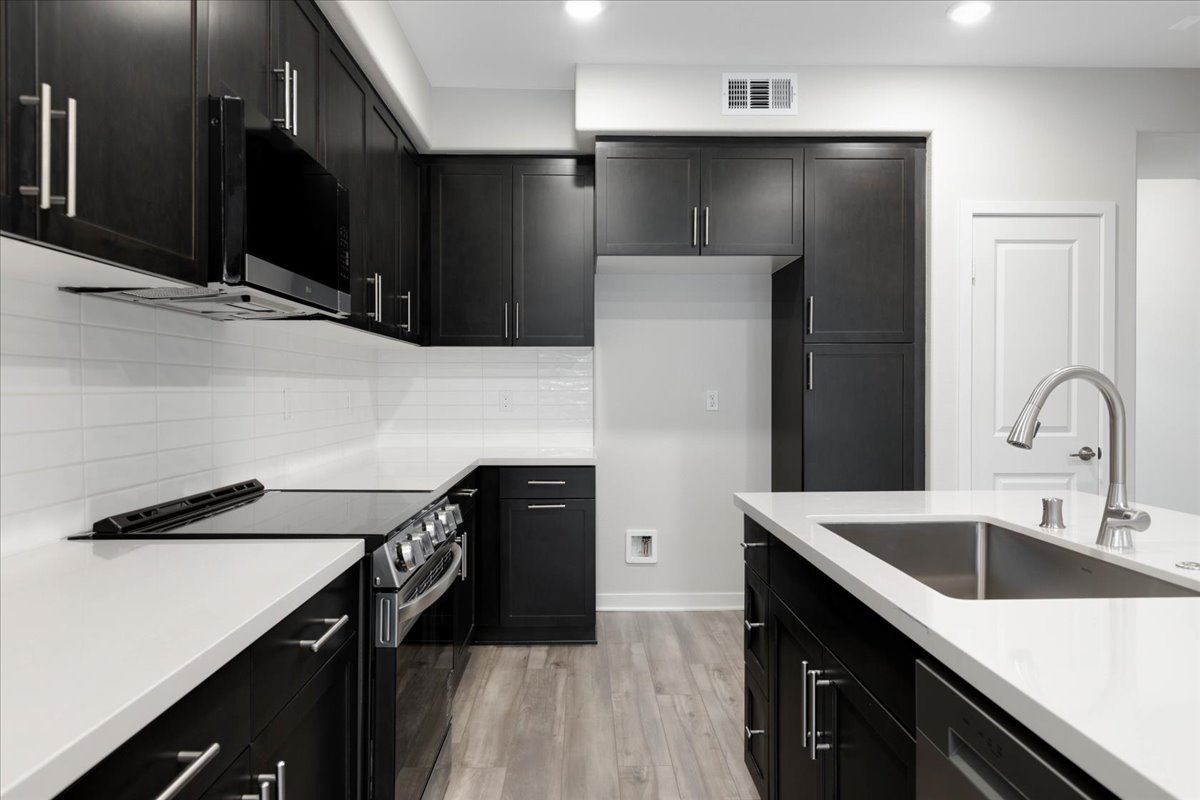 A kitchen with black cabinets.