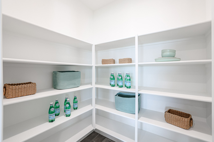 A white shelving unit with many bottles and baskets.