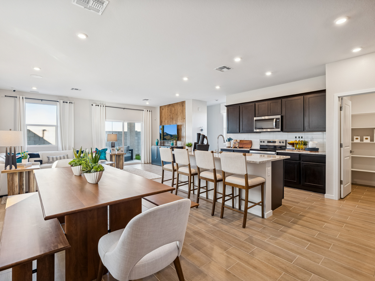 A kitchen with a dining table and chairs.
