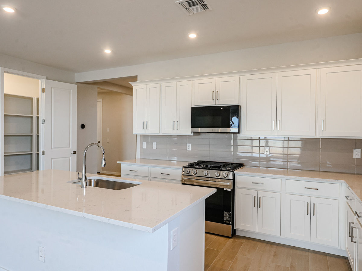 A kitchen with white cabinets.