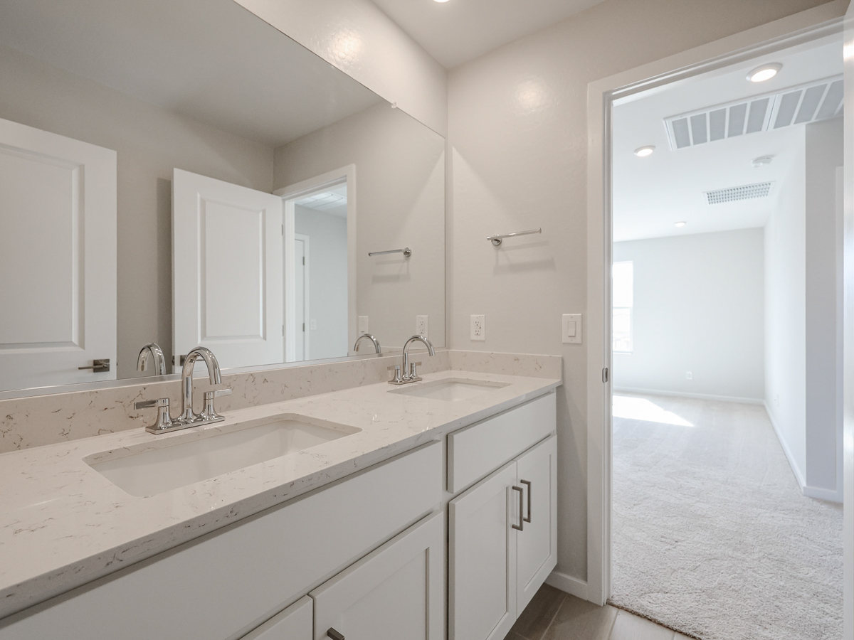 A bathroom with white cabinets.