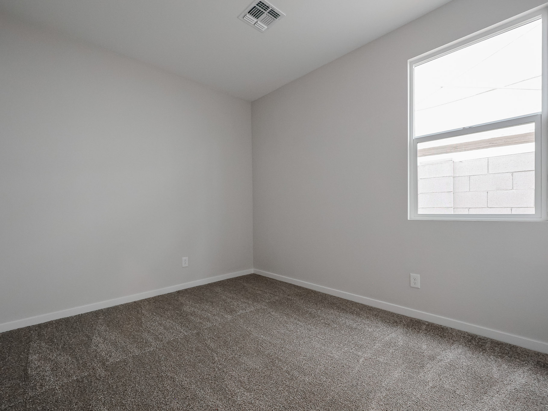 A room with a carpet and a window.