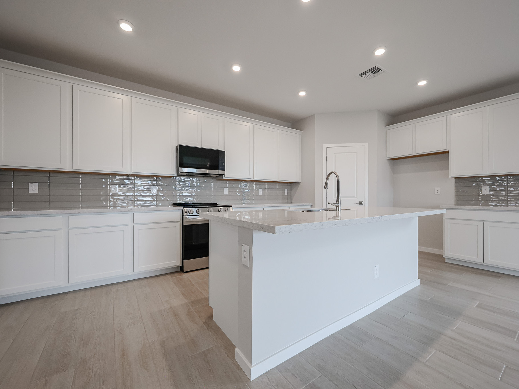 A kitchen with white cabinets.