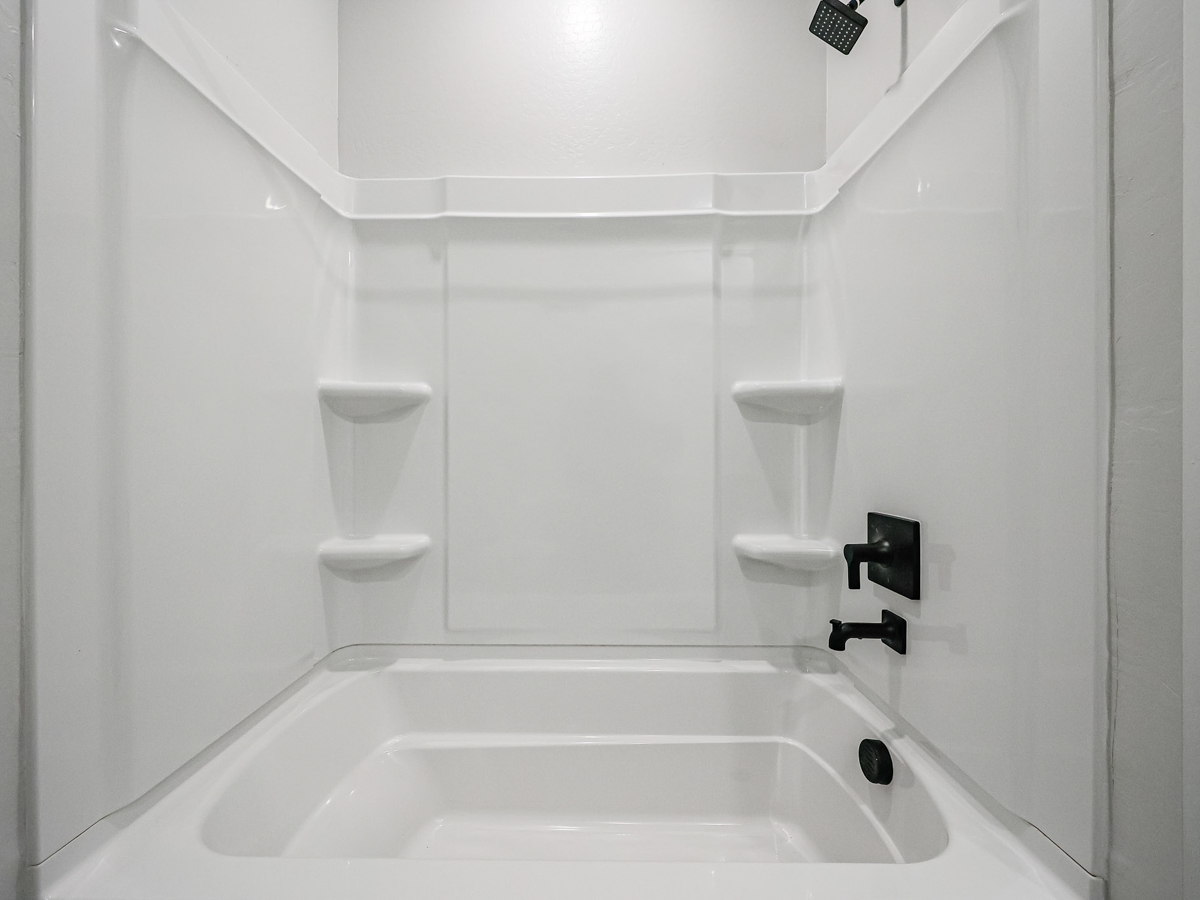 A bathroom with a tub and toilet.