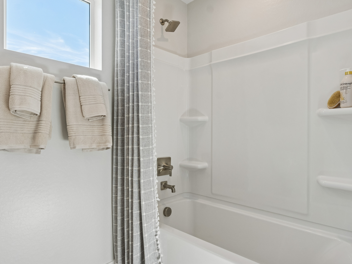A bathroom with a bathtub and towels.