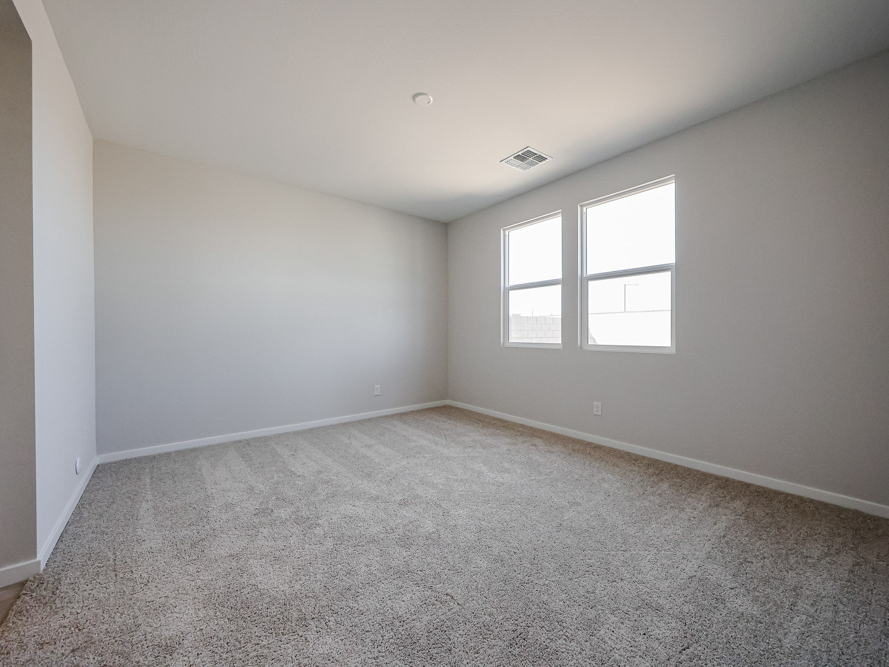 A room with a carpet and windows.