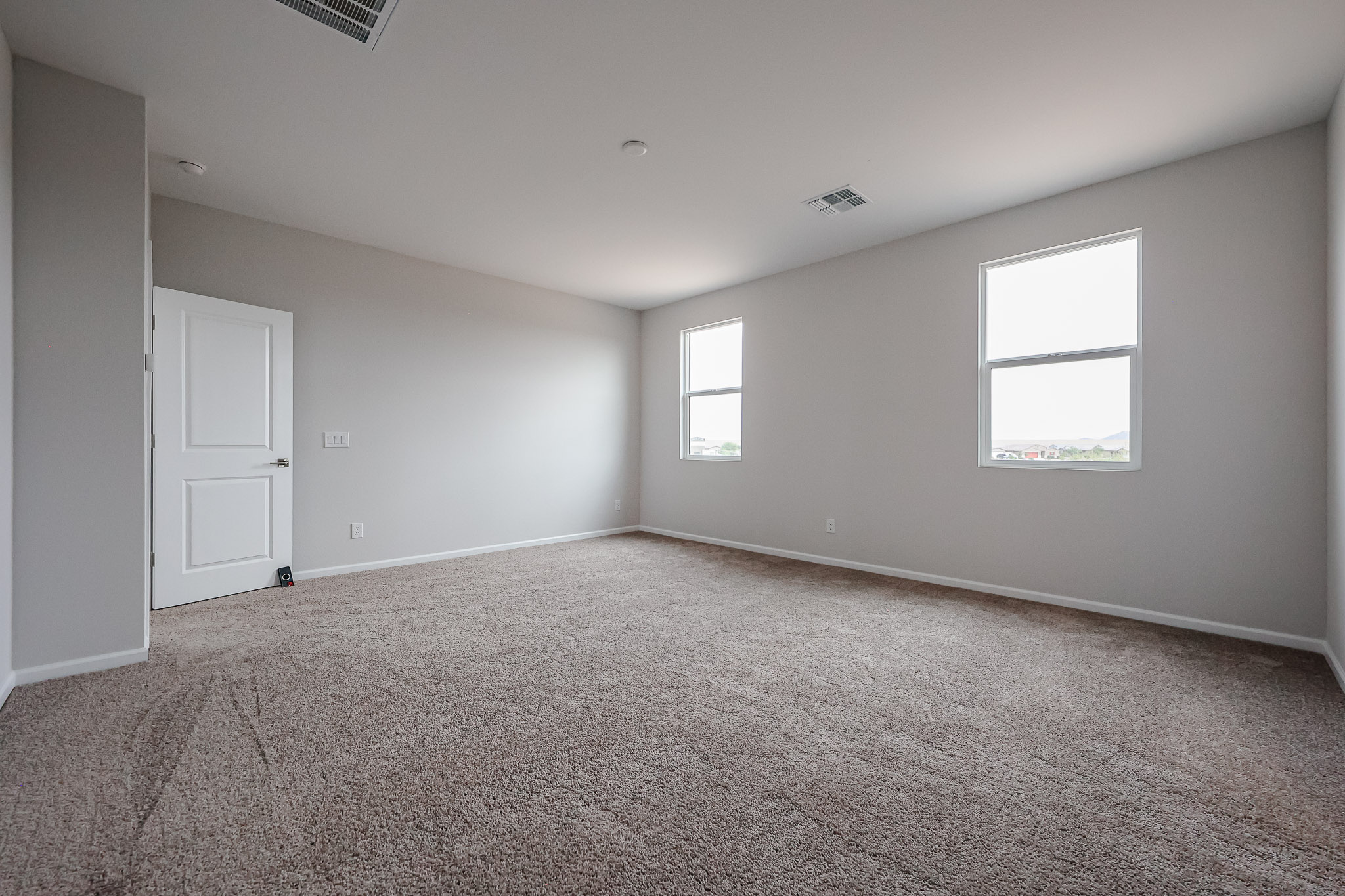 A room with a carpet and a door.