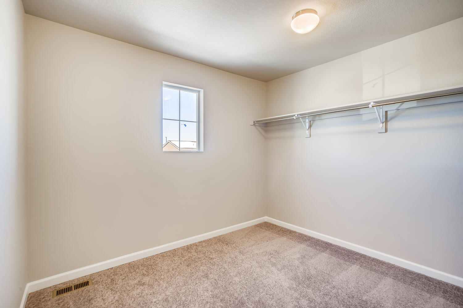 A room with a window and a carpet.