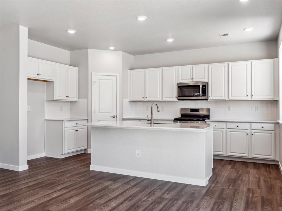 A kitchen with white cabinets.