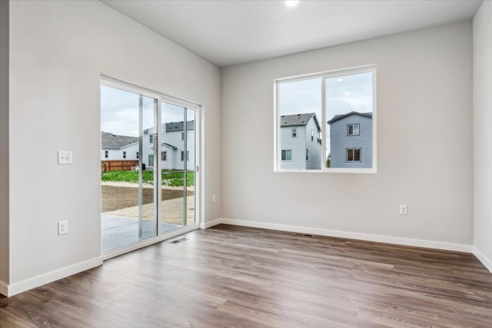 A room with a wood floor and a large window.