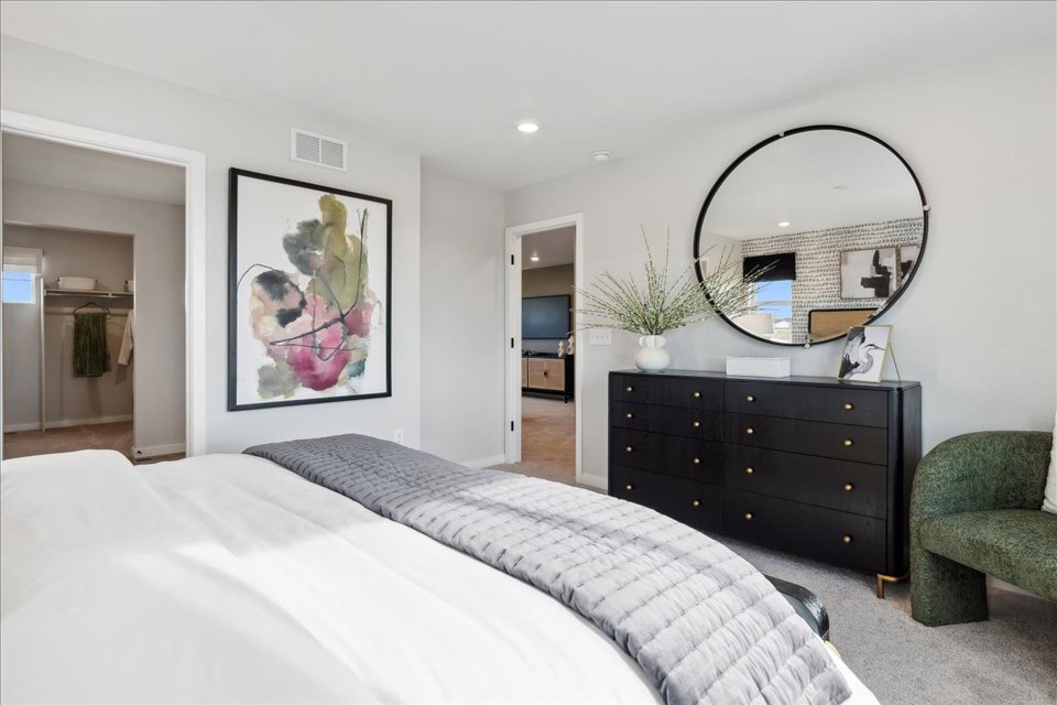 A bedroom with a bed and a dresser.