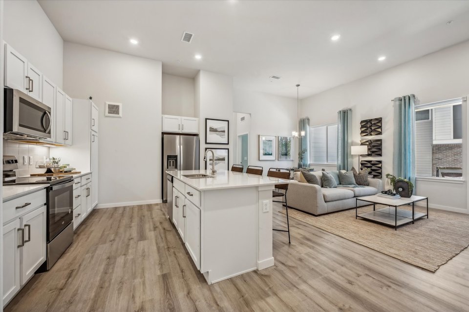 A large kitchen with a wood floor.