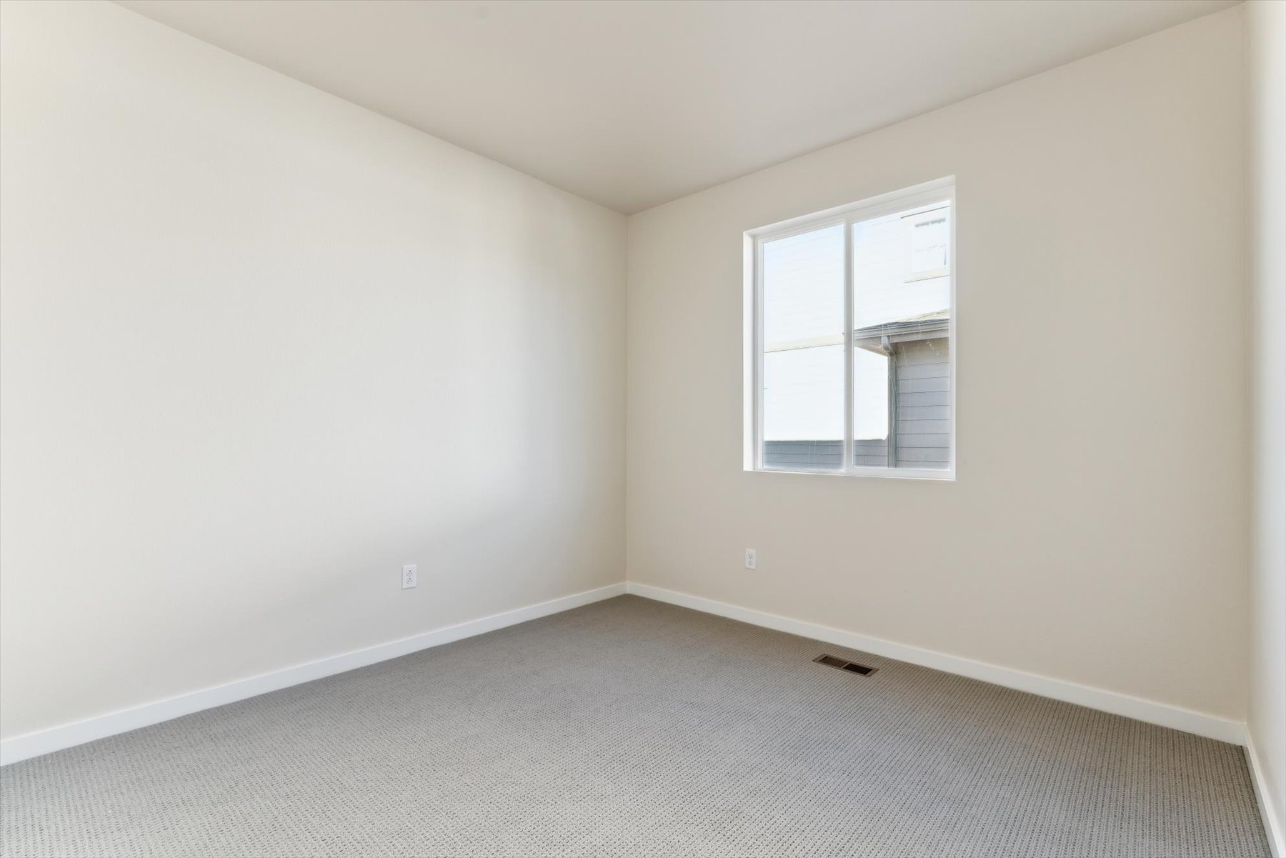 A room with a window and a carpet.