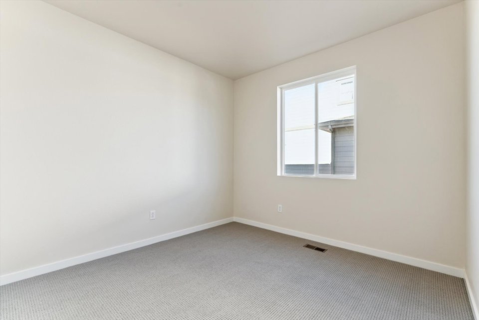 A room with a window and a carpet.