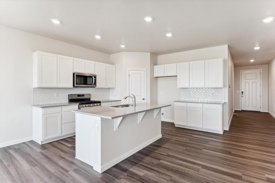 A kitchen with white cabinets.
