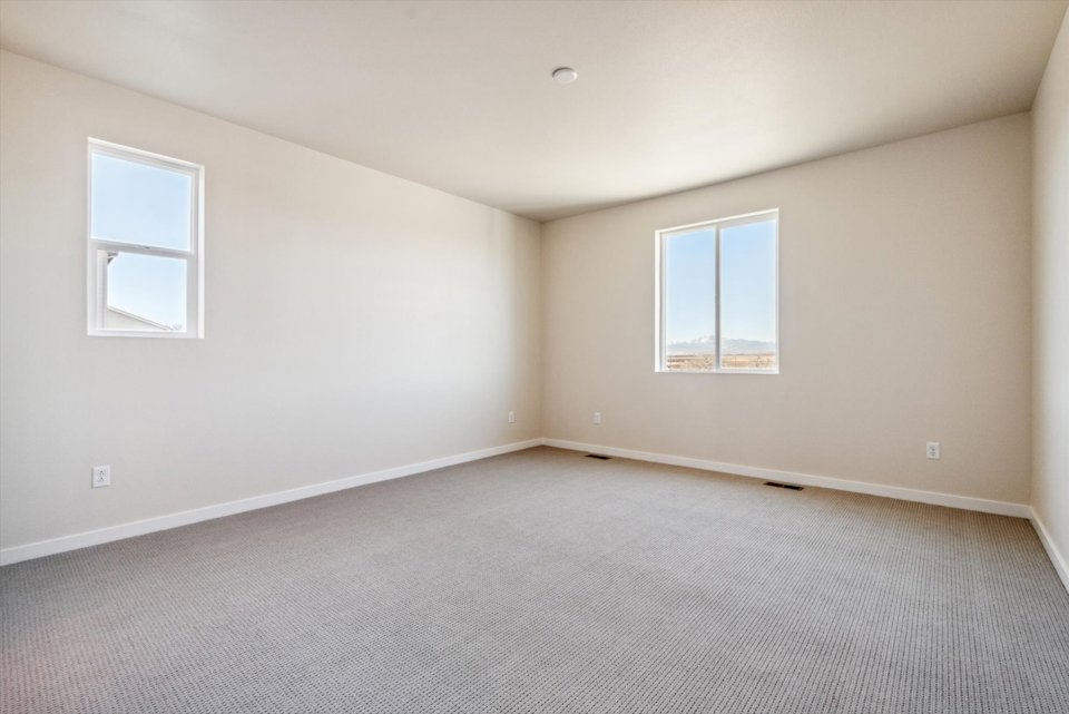 A room with a carpet and windows.