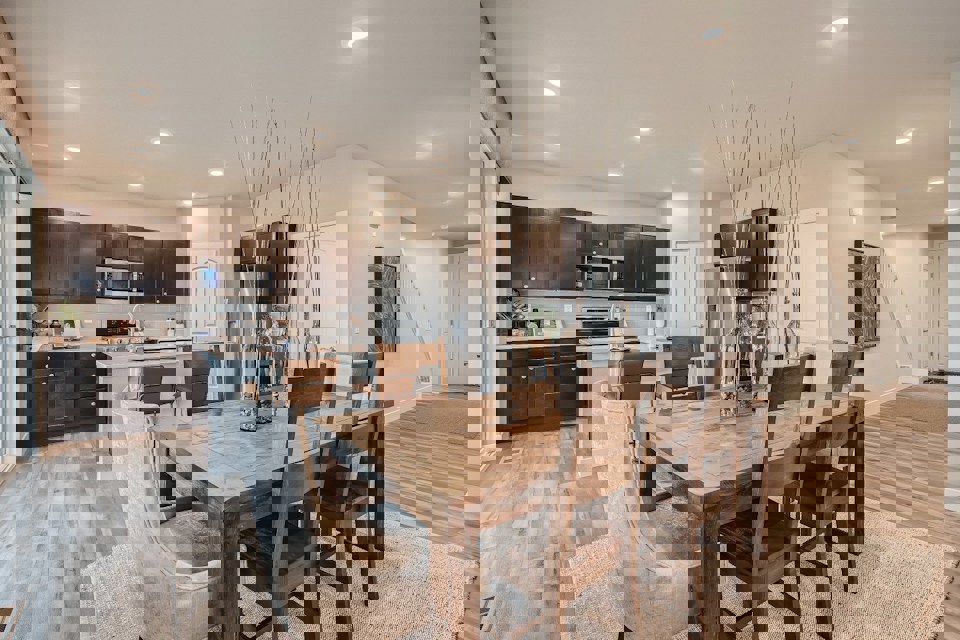 A dining room table with a chandelier from it.