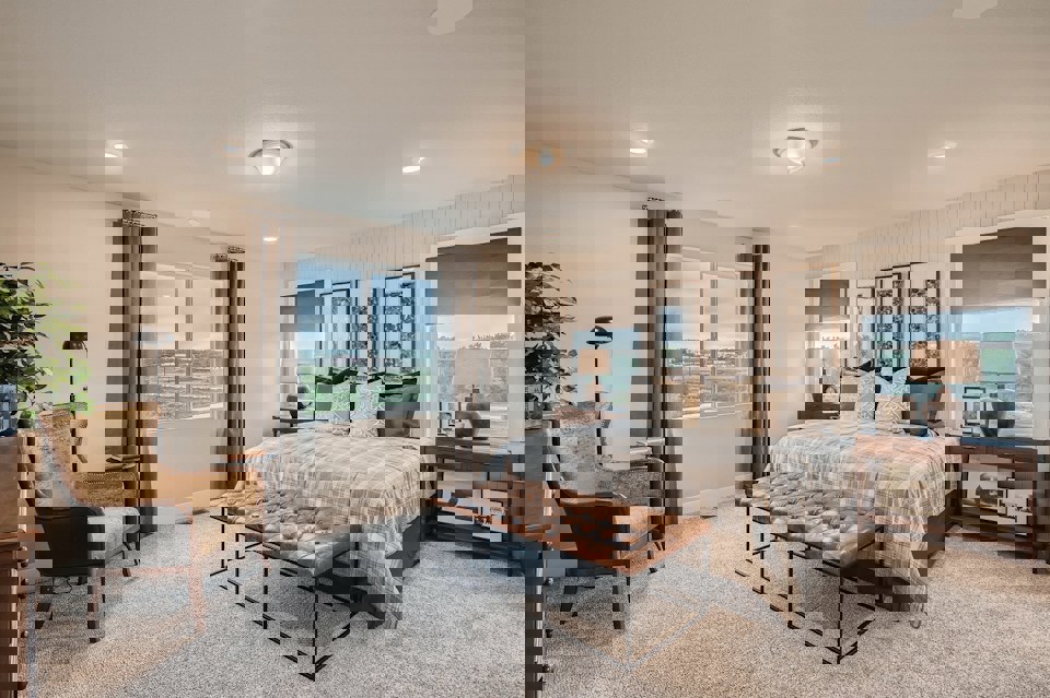 A bedroom with a bed and a chair.