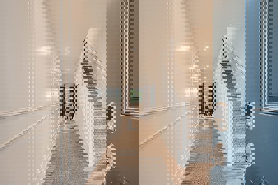 A hallway with a staircase.