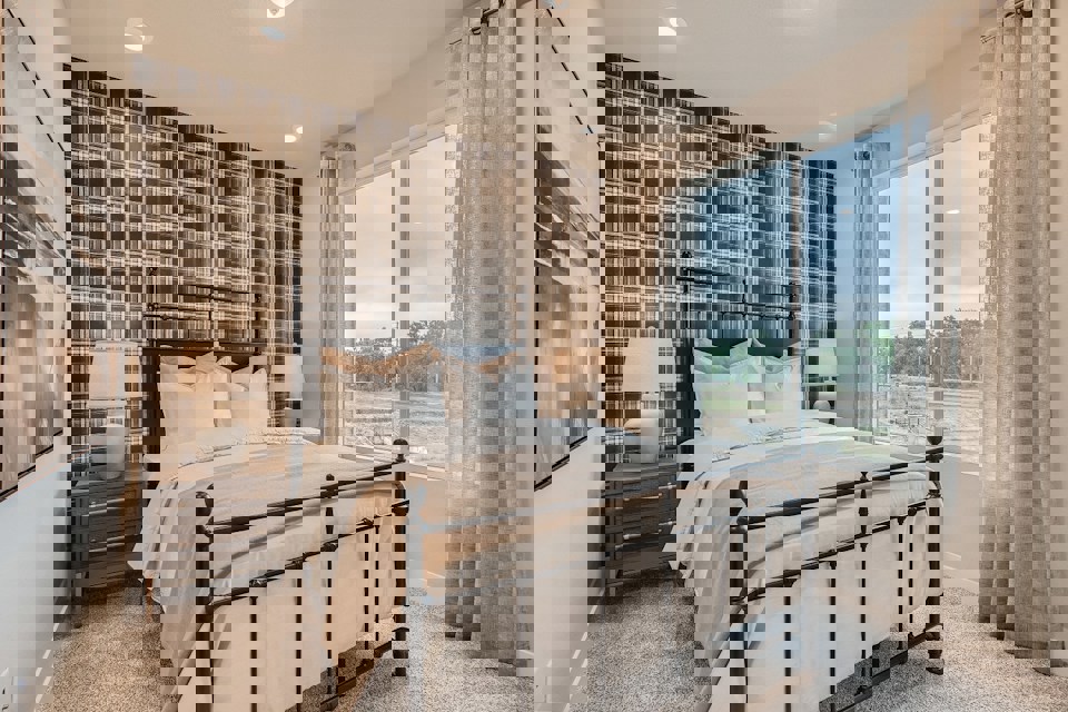 A bedroom with a large window.