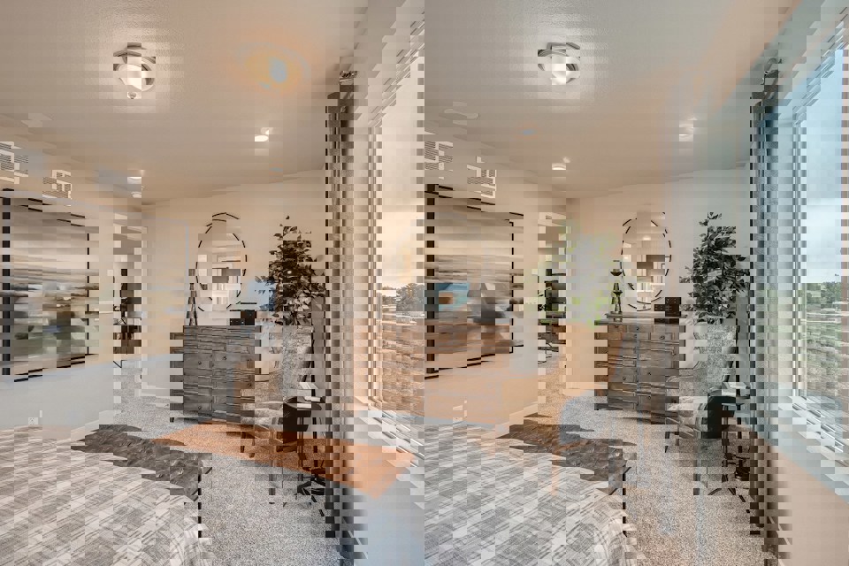 A bedroom with a bed and a chair.