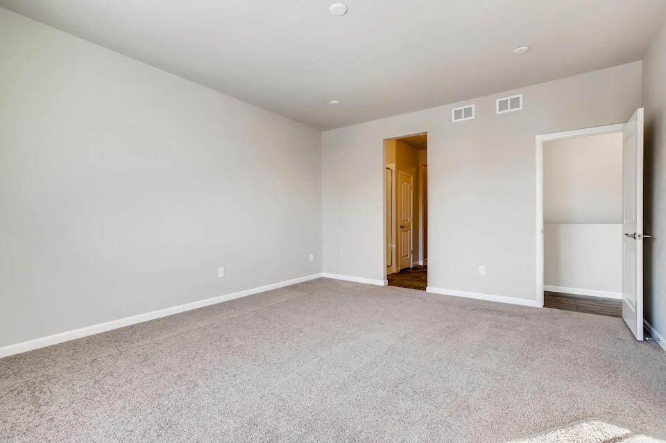 A room with a carpet and a door.