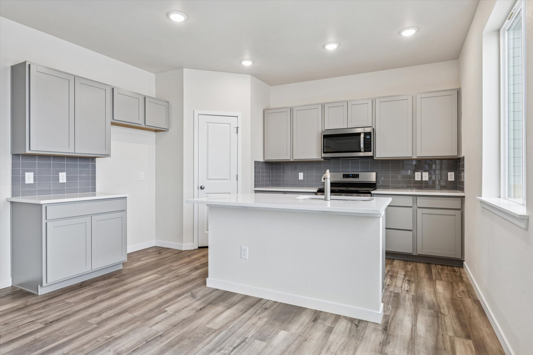 A kitchen with white cabinets.