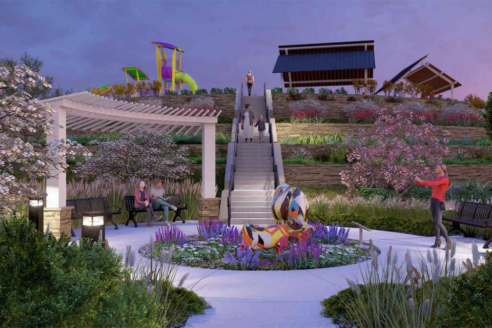 A group of people sitting on a bench in a garden.