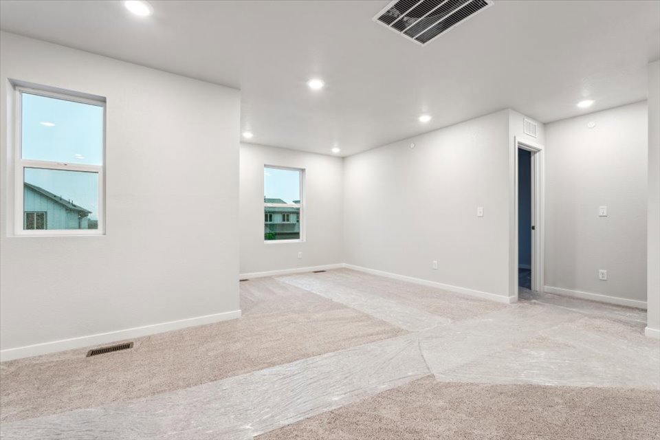 A room with a carpet and windows.