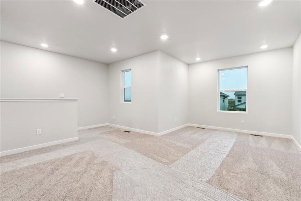 A large empty room with a rug.