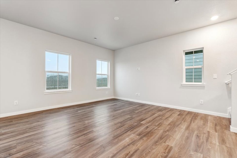 A room with windows and wood floors.