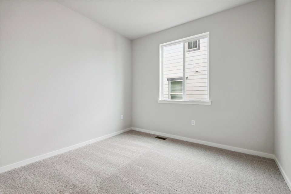 A room with a window and a carpet.