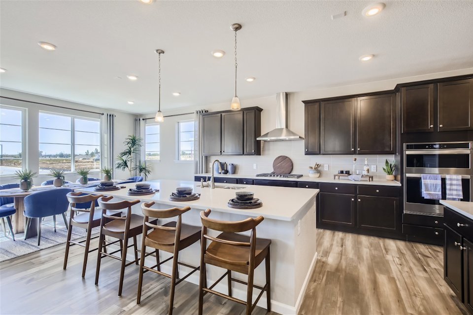 A kitchen with a dining table and chairs.