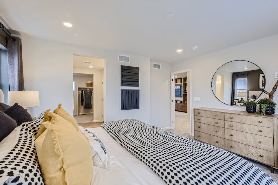 A bedroom with a bed and a mirror.