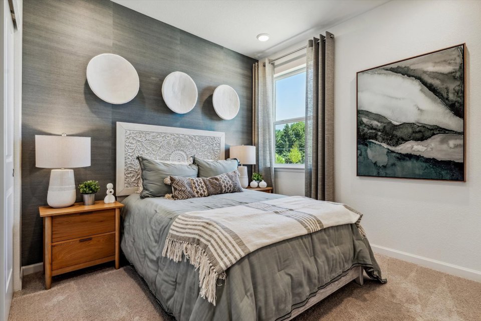 A bedroom with a bed and lamps.