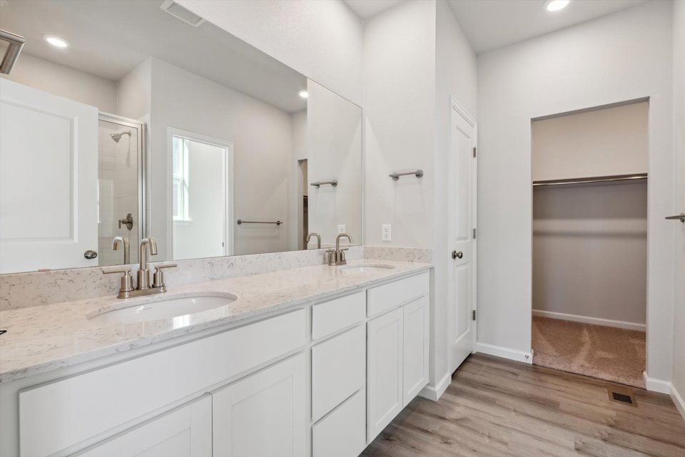 A bathroom with white cabinets.