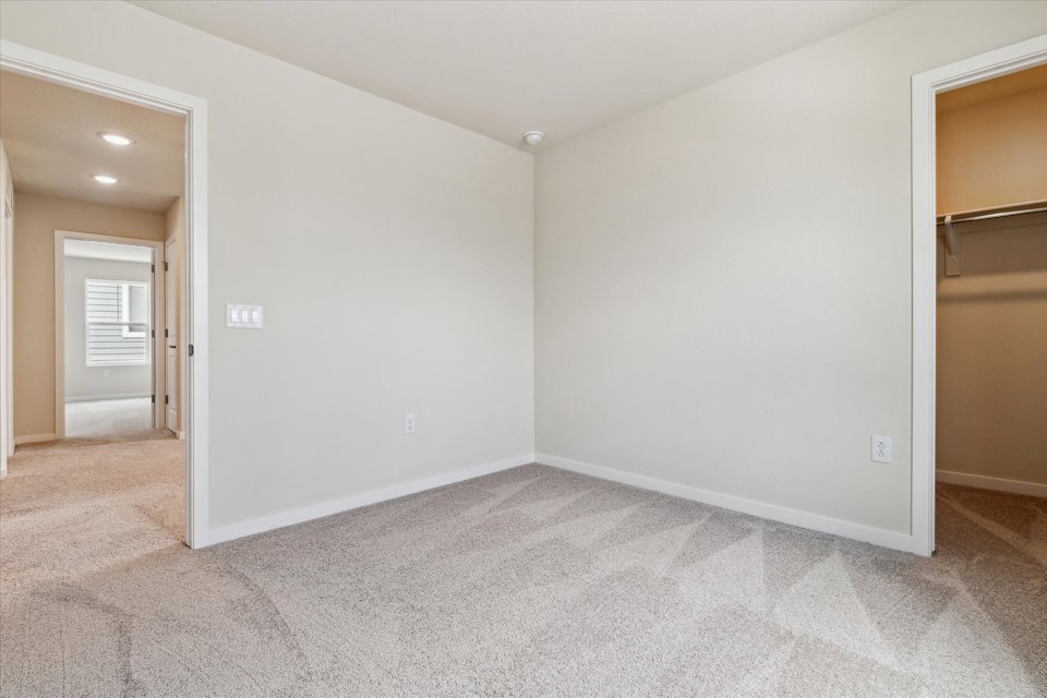 A room with a carpet and a door.