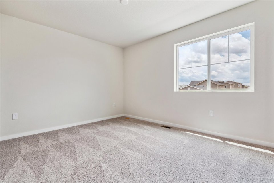 A room with a window and a carpet.