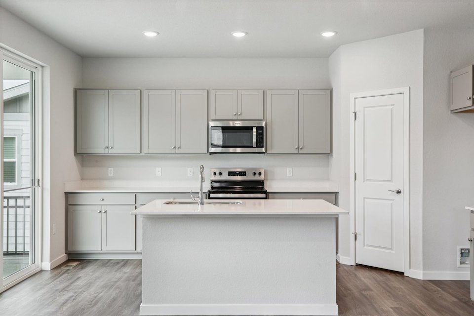 A kitchen with white cabinets.