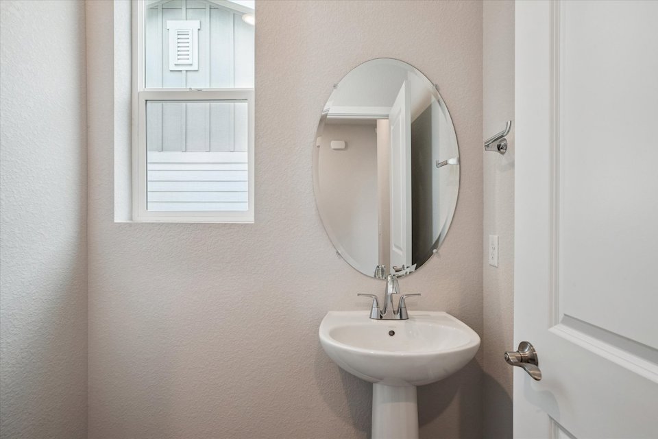 A bathroom with a round mirror.