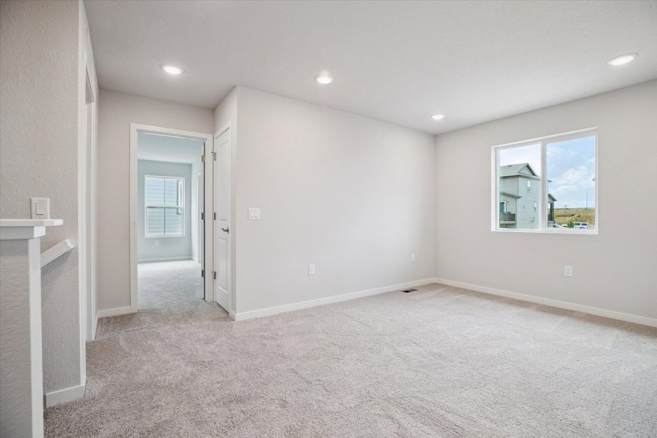 A room with a white wall and a window.